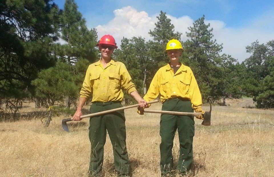 Bill Duguay (left) and Johnnie Duguay work on a fire together. All firefighters have personal protective equipment they bring with them. Johnnie’s favorite part of fire fighting is “mopping up,” checking for hot spots in burned-out areas of a fire. CREDIT: JENNIFER DUGUAY