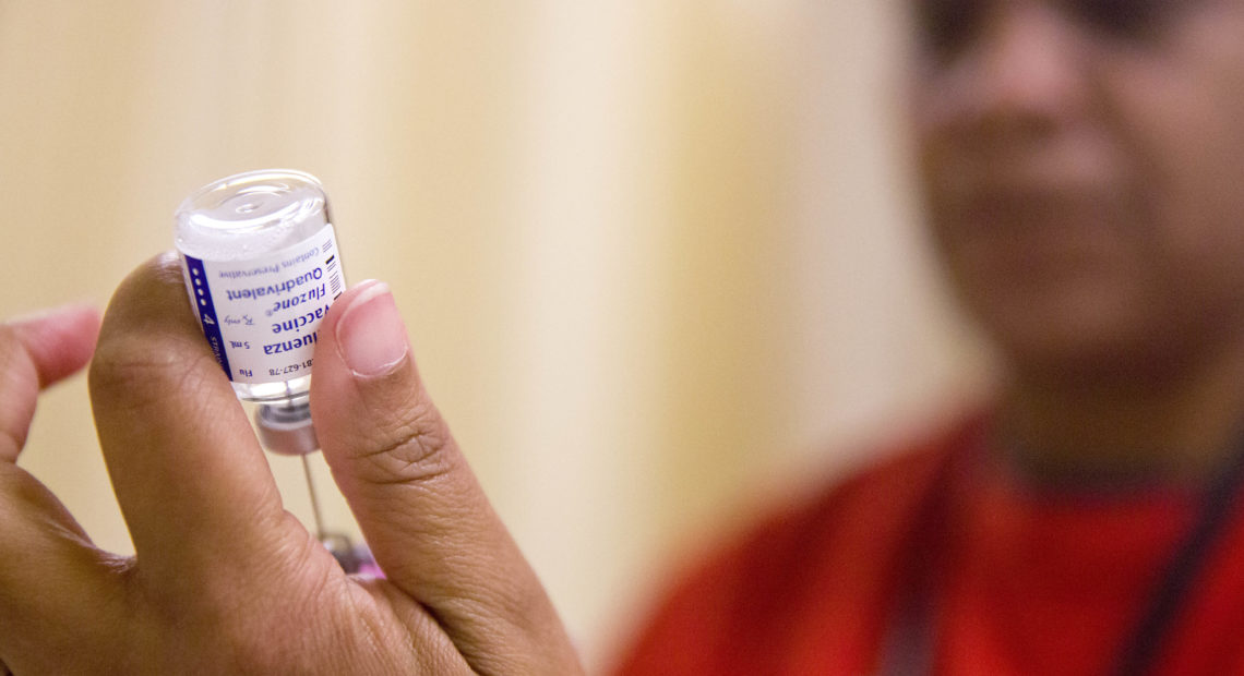 A nurse prepares a flu shot from a vaccine vial. CREDIT: DAVID GOLDMAN