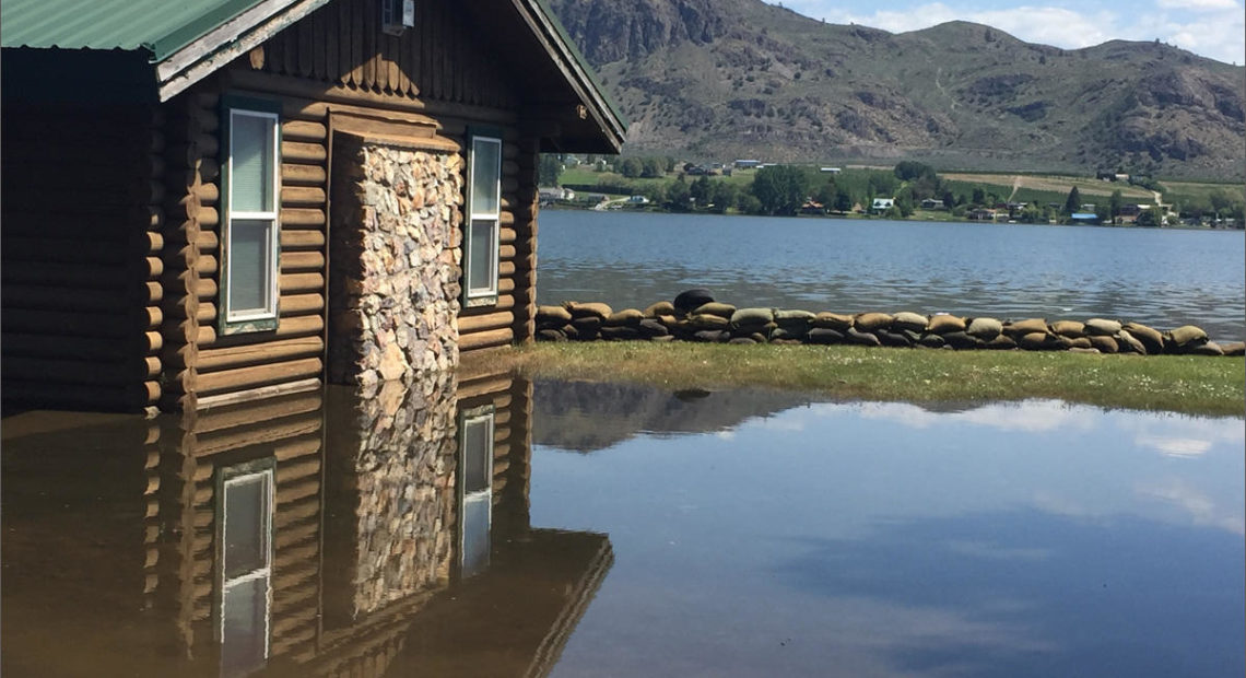 A home along Lake Osoyoos in Oroville, Washington, is already inundated with flood water. A near record snow year in southern British Columbia combined with temperatures in the upper 80s means flood waters will continue to rise. CREDIT: EMILY SCHWING/NORTHWEST NEWS NETWORK