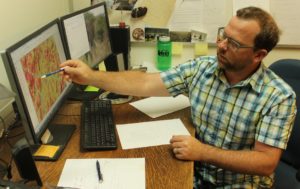 Oregon State University professor Chris Dunn examines a map of the likelihood of success for fire suppression in southern Oregon. Dunn is part of a Forest Service team using data to improve decision-making and risk assessment. CREDIT: TONY SCHICK/OPB