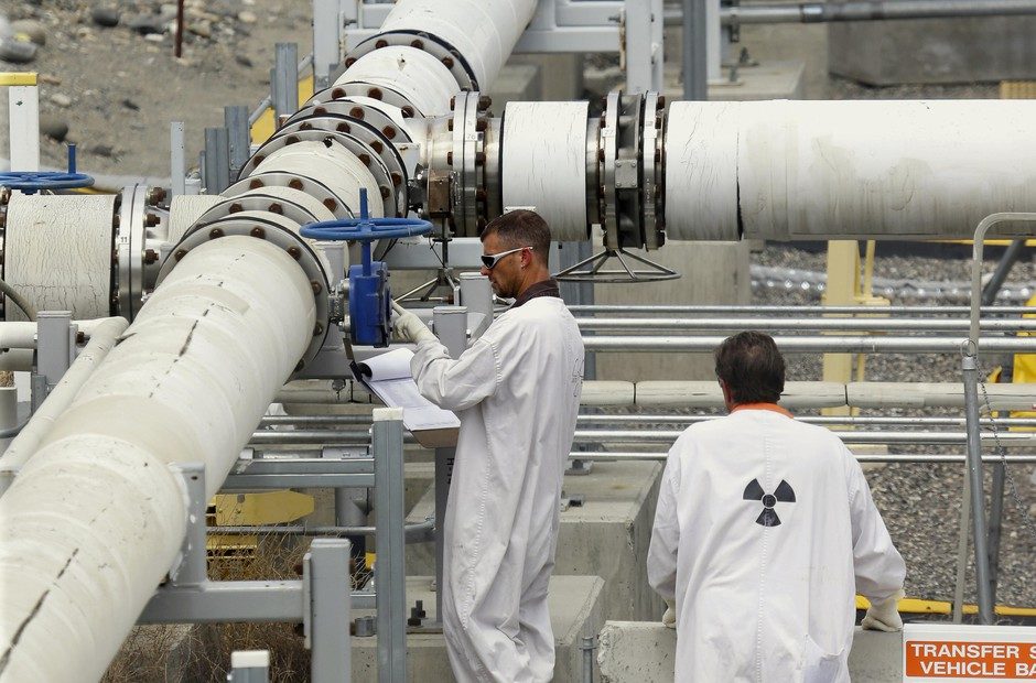 In this July 9, 2014, file photo, workers wearing protective clothing and footwear inspect a valve at the "C" tank farm on the Hanford Nuclear Reservation near Richland, Wash. CREDIT: TED S. WARREN