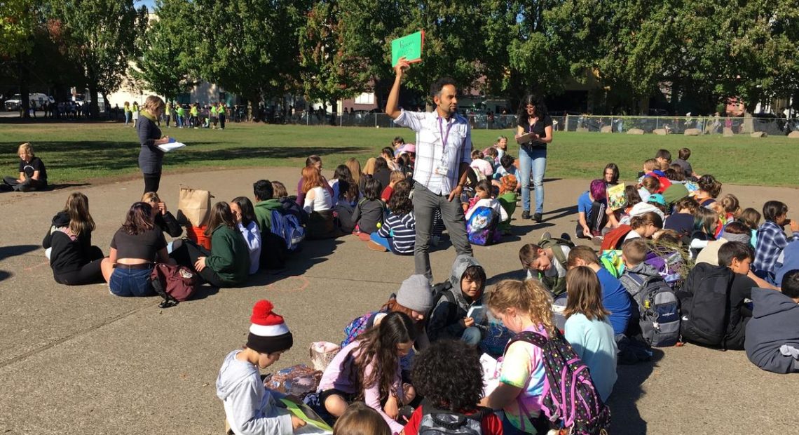 Teacher Jeremy Thomas holds up an all-accounted-for sign after the school evacuation. CREDIT: TOM BANSE / N3