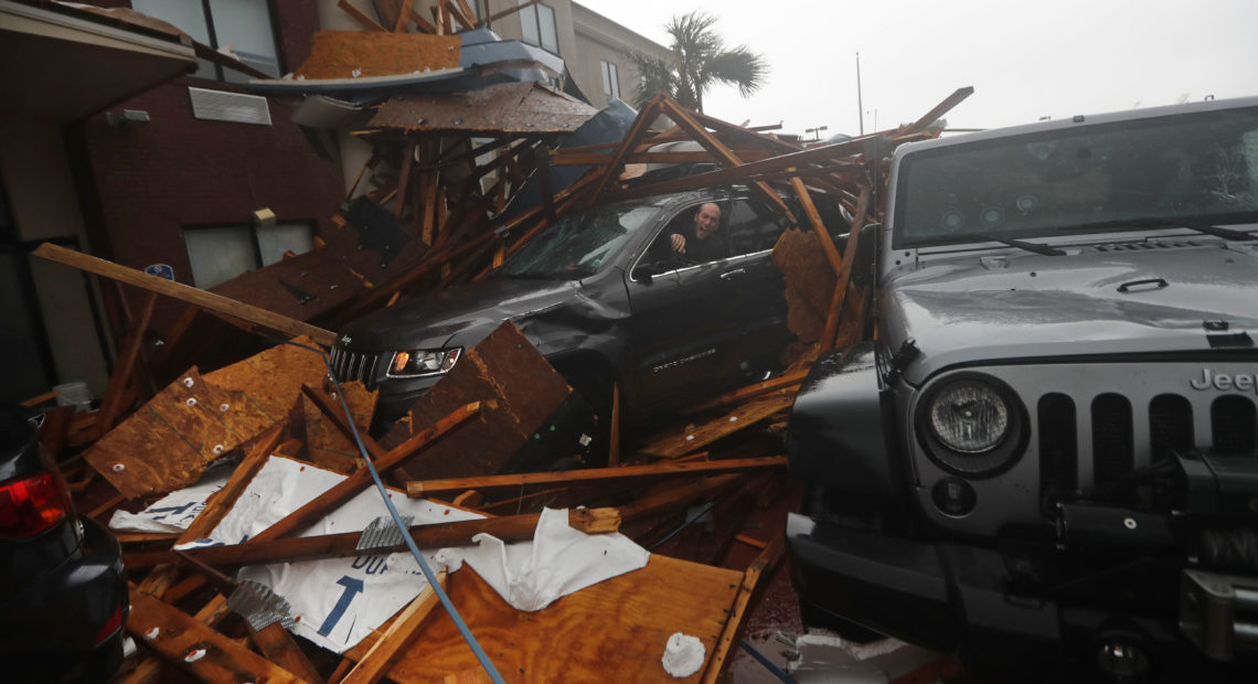 A storm chaser climbs into his vehicle as the eye of Hurricane Michael passes over Panama City Beach, Fla., hoping to retrieve his equipment after a hotel canopy collapsed in the parking area. The storm came ashore as a nearly Category 5 hurricane Wednesday.