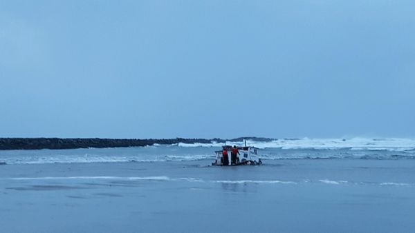 Newport, Ore., examine the wreckage of the Mary B. II, a commercial crabbing that capsized while crossing Yaquina Bay Bar off the coast of Newport, Ore. Three crew members died in the accident. CREDIT: US COAST GUARD