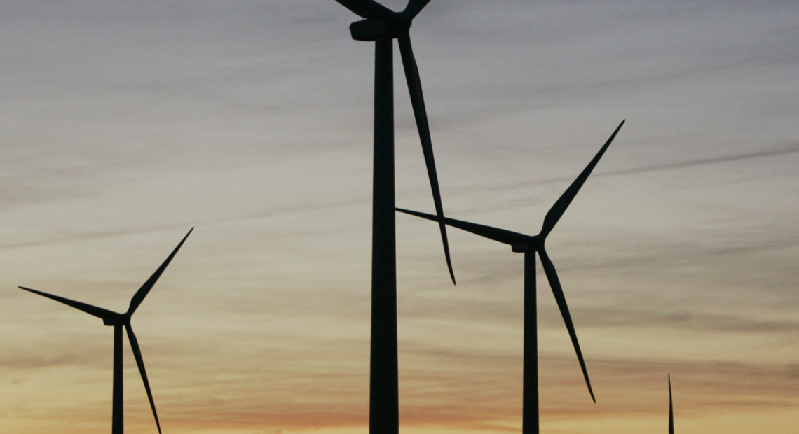 A wind mill supplies water to a stock tank, surrounded by wind turbines of the Smoky Hills Wind Project near Wilson, Kansas. CREDIT: ORLIN WAGNER/AP