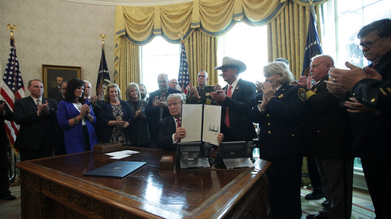 President Trump shows the executive veto of the national emergency resolution in the Oval Office of the White House Friday. Alex Wong/Getty Images