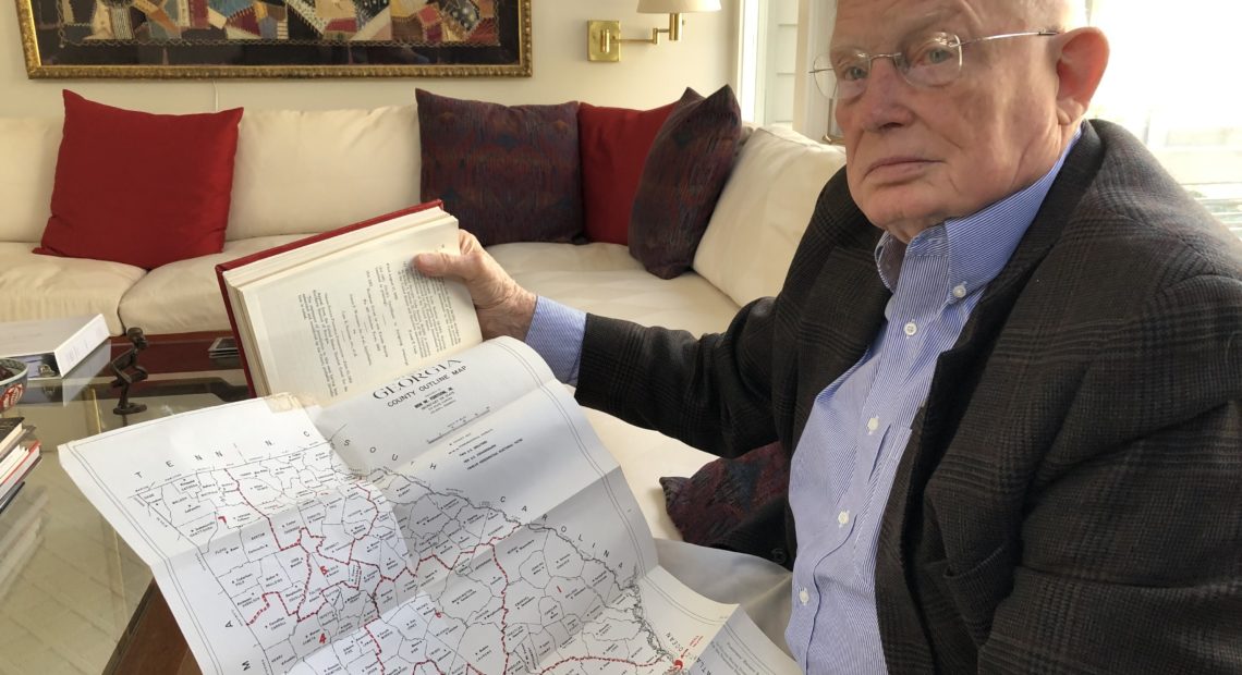 Attorney Emmet Bondurant holds a map of Georgia's congressional districts around the early 1960s, exhibit #9 in the Wesberry v. Sanders case he argued before the Supreme Court as a young lawyer. CREDIT: Johnny Kaufman/WABE