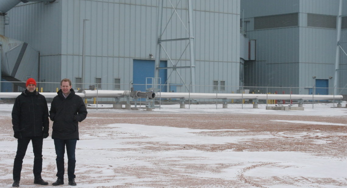 Jason Salfi, left, and Dr. David Erickson, right, of Dimensional Energy, are finalists in the Carbon XPRIZE. They stand in front of the Dry Fork Station coal-fired power plant in Gillette, Wyo., where the competition is located. CREDIT: COOPER MCKIM/WYOMING PUBLIC RADIO