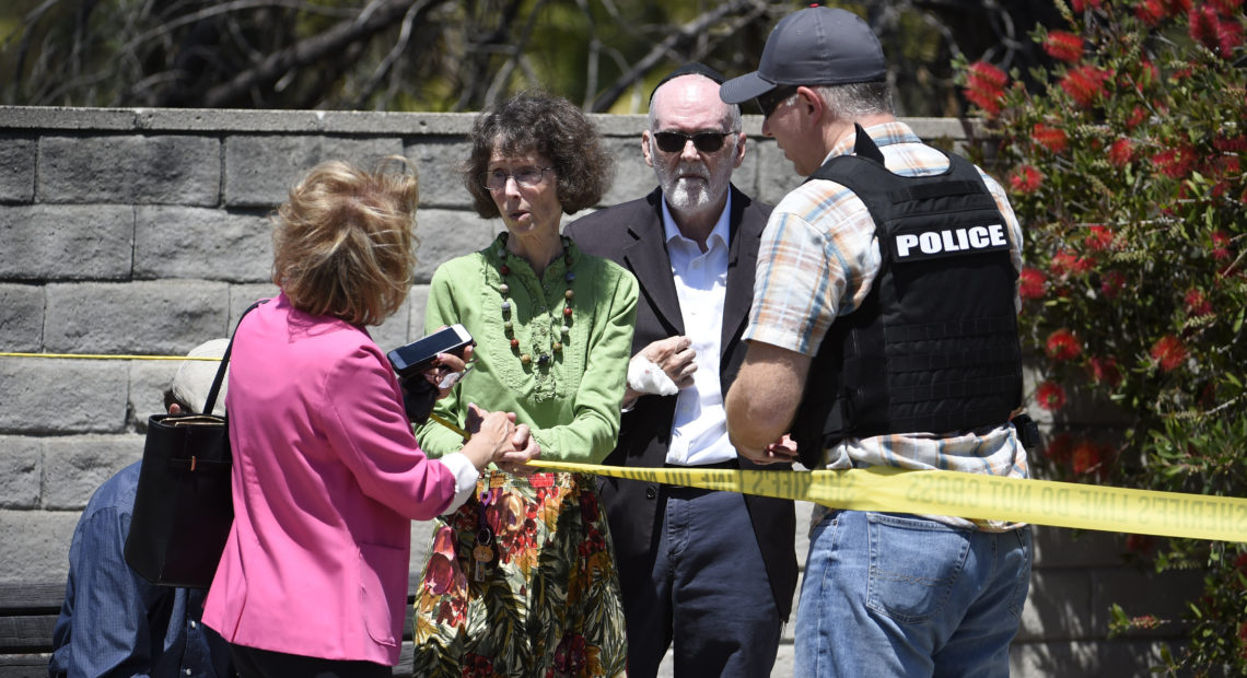 Synagogue members talk to a San Diego County Sheriff's deputy outside of the Chabad of Poway Synagogue on Saturday in Poway, Calif. Denis Poroy/AP