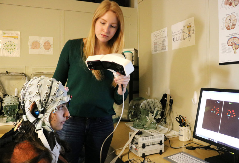 A lab member tests transcranial brain stimulation on a research subject at Boston University. Courtesy of Rob Reinhart