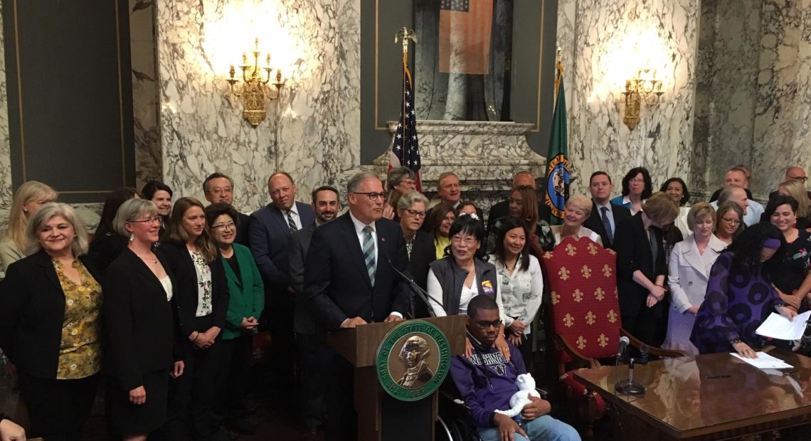 Washington Gov. Jay Inslee signed two historic bills into law on Monday. One creates a public health insurance option, the other a new long-term care benefit. CREDIT: AUSTIN JENKINS / NORTHWEST NEWS NETWORK