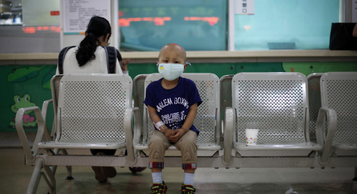 Four-year-old Niuniu, who has late-stage neuroblastoma, a malignant cancer of the nervous system, sits on a bench while his mother pays his medical bills after getting tested for his fifth round of chemotherapy at Shanghai Children's Hospital in 2013. CREDIT: ALY SONG/REUTERS