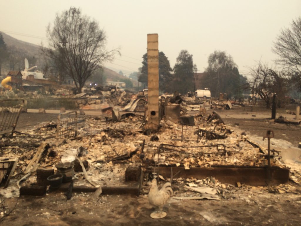 About 20 homes burned in this Pateros neighborhood, which included the mayor at the time, Libby Harrison, and her mom’s home behind her. The community church behind it survived, but the pastor’s home next door burned. CREDIT: Scott A. Leadingham