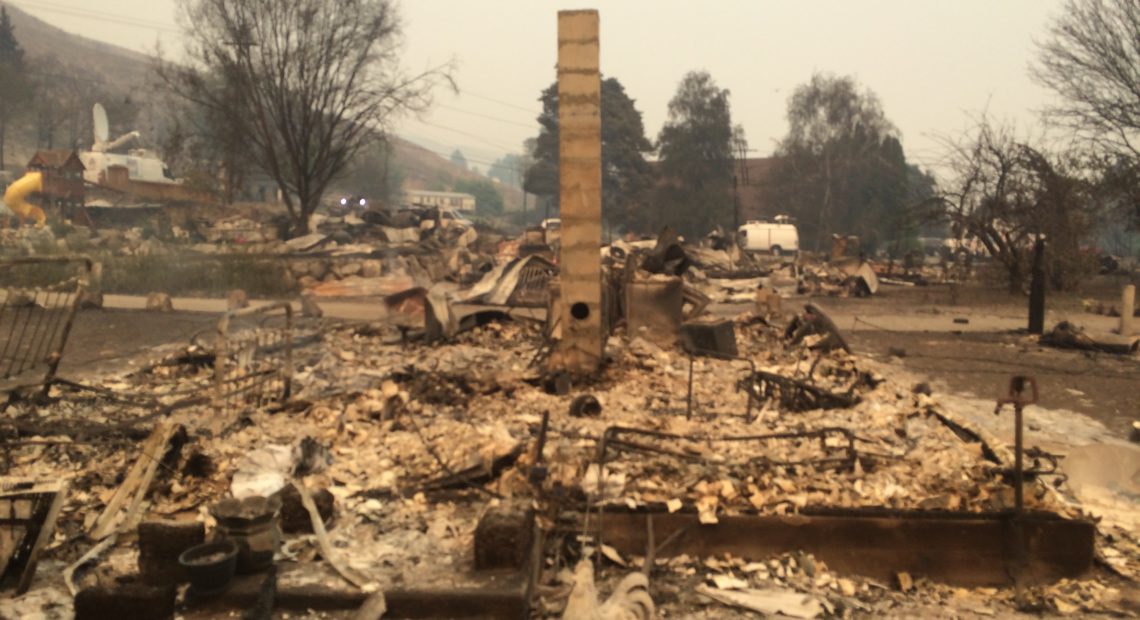 About 20 homes burned in this Pateros neighborhood, which included the mayor at the time, Libby Harrison, and her mom’s home behind her. The community church behind it survived, but the pastor’s home next door burned. CREDIT: Scott A. Leadingham