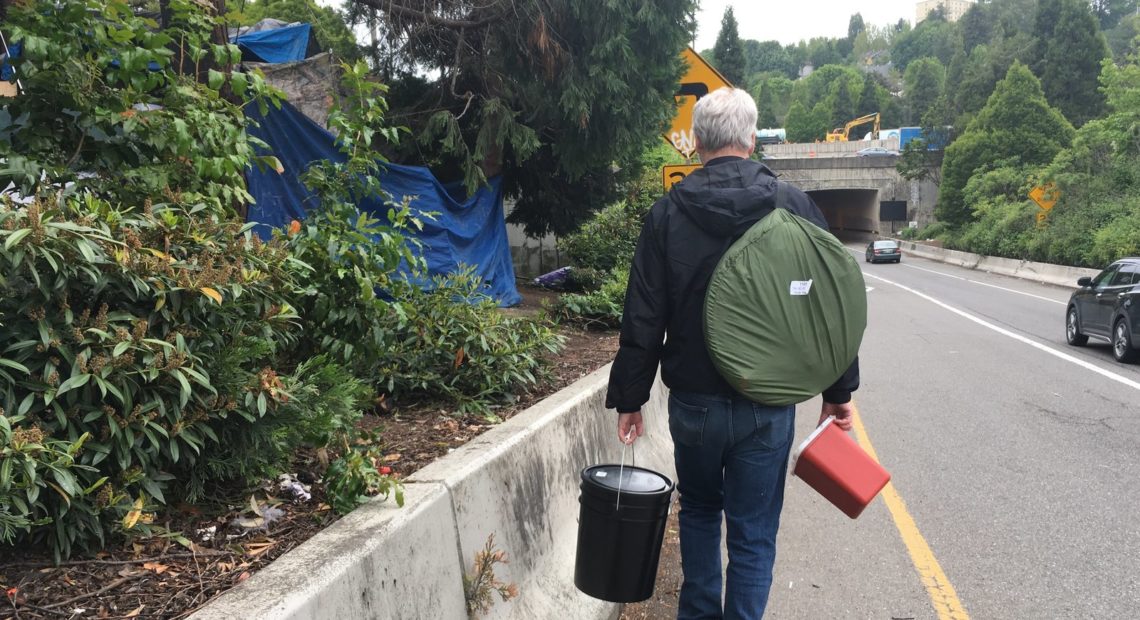 Seattle tech worker Mark Lloyd navigates the city's homeless encampments, giving away toilet kits and connecting with people. Gabriel Spitzer /KNKX