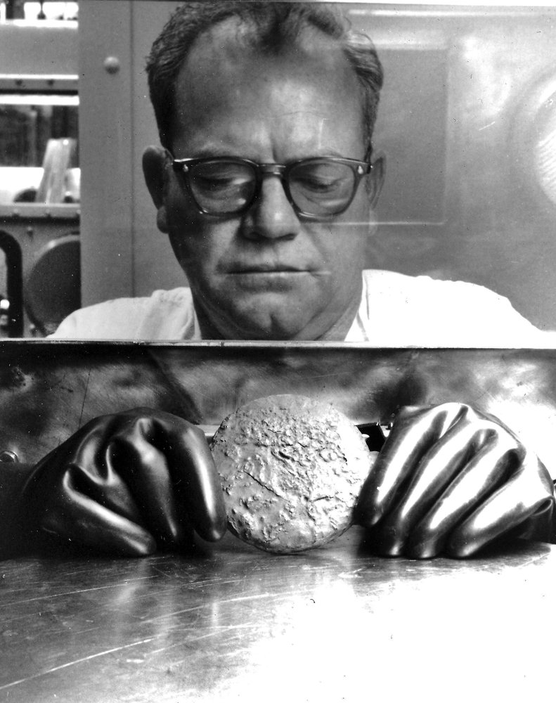 In this Sept. 19, 1973 photo provided by the U.S. Department of Energy, a worker holds a plutonium "button" inside a chamber using protective gloves at the Rocky Flats nuclear weapons plant northwest of Denver. The U.S. Energy Department manufactured plutonium triggers for nuclear warheads at Rocky Flats. It had a long history of leaks, fires and environmental violations. CREDIT: U.S. DEPT. OF ENERGY via AP