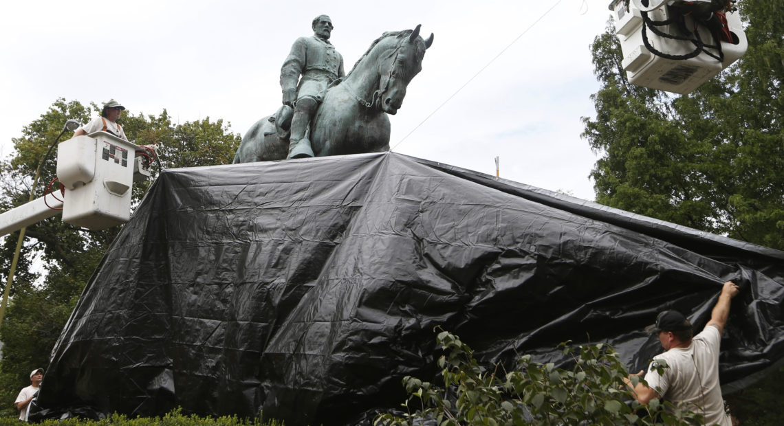 City workers drape a tarp over the statue of Confederate General Robert E. Lee in Charlottesville, Va. on Aug. 23, 2017. Steve Helber/AP