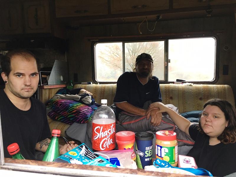 Austin Hall, left, his fiance Victoria Swan and a man who identified himself as Mark Goddard sit in one of the RVs parked on Deschutes Parkway on Washington's Capitol campus. CREDIT: Austin Jenkins/N3