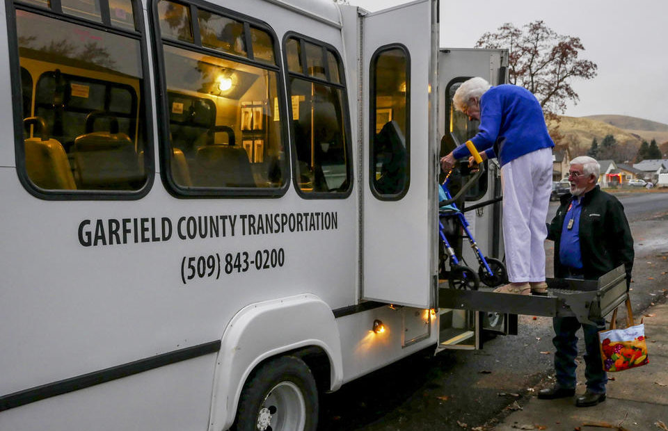 Garfield County Transportation Authority driver Gene Smith helps 96-year-old resident Louise Munday board a commuter bus on Nov. 15, 2019. Munday uses local transit five days a week and, with her limited mobility, the service to her door is necessary. CREDIT: Emily McCarty/Crosscut