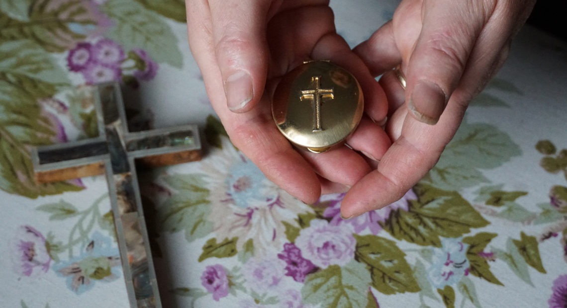 Marie Andrews holds a pyx, the vessel she uses to transport the consecrated Communion wafer to homebound parishioners. Andrews is an officially sanctioned Eucharistic minister in the Roman Catholic Church. CREDIT: Shahla Farzan/St. Louis Public Radio