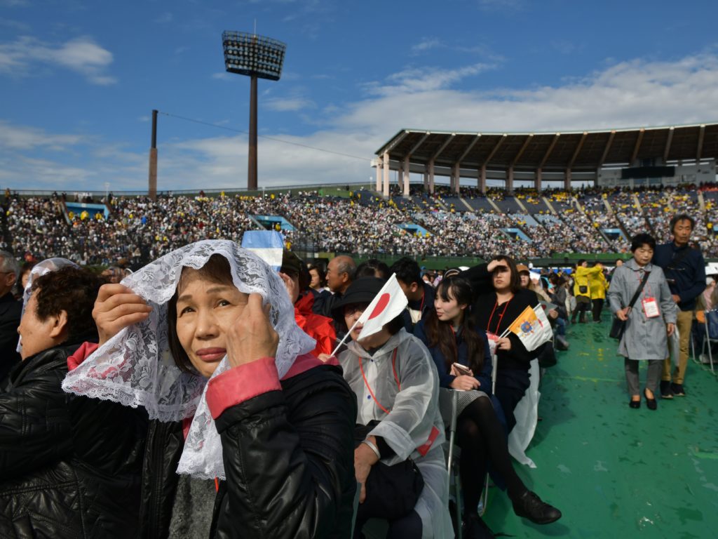 Attendees wait for a Holy Mass led by Pope Francis at a baseball stadium in Nagasaki on Sunday. CREDIT: Ed Jones/AFP via Getty Images