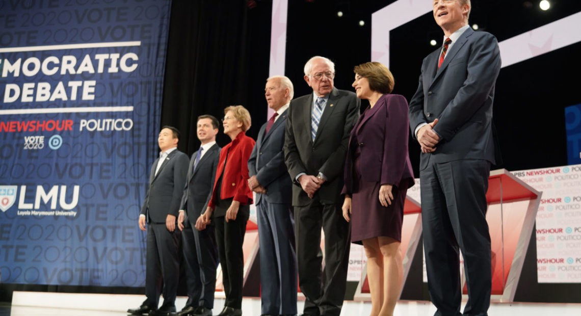 Democratic presidential candidates entrepreneur Andrew Yang, South Bend Mayor Pete Buttigieg, Senator Elizabeth Warren, former Vice President Joe Biden, Senator Bernie Sanders, Senator Amy Klobuchar and billionaire activist Tom Steyer take the stage for the sixth 2020 U.S. Democratic presidential candidates campaign debate at Loyola Marymount University in Los Angeles. CREDIT: PBS NewsHour