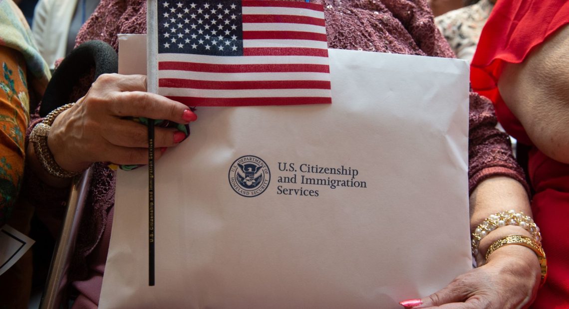 A newly sworn-in U.S. citizen holds the U.S. flag and paperwork during a 2018 naturalization ceremony in New York City. The Department of Homeland Security has agreed to share its records with the U.S. Census Bureau to help produce data about the U.S. citizenship status of every person living in the country, as ordered by President Trump. CREDIT: Bryan R. Smith/AFP via Getty Images