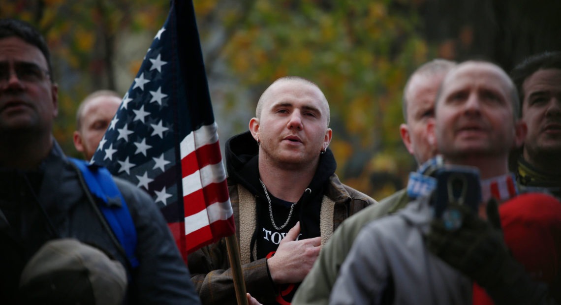 Attendees recite the Pledge of Allegiance during the United Against Hate rally by the Washington Three Percent in Seattle last month. CREDIT: Jim Urquhart for NPR