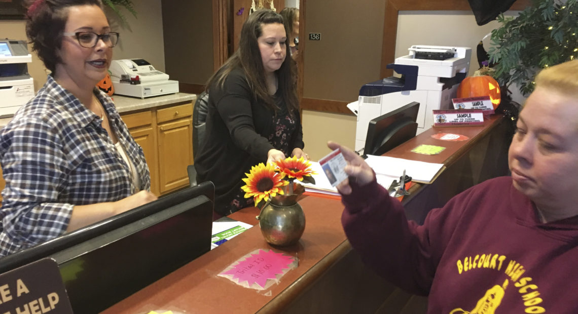 Delaine Belgarde (right) shows the new Turtle Mountain Band of Chippewa identification card, in Belcourt, N.D., in 2018. CREDIT: Blake Nicholson/AP