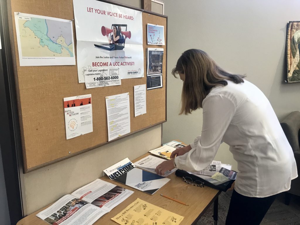 Shalom United Church of Christ member Lora Rathbone helps run the church’s social action table. She answers people’s questions about environmental advocacy and provides information about legislative bills the church supports. CREDIT: Courtney Flatt/NWPB