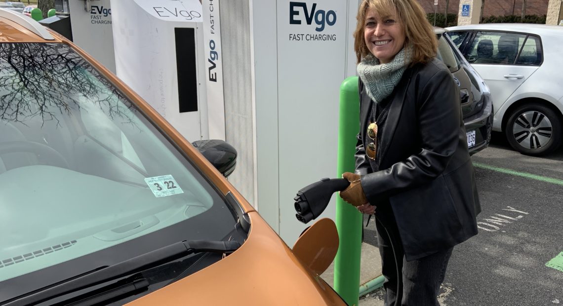 Pam Frank, CEO of ChargEVC, drives a bright Orange Chevrolet Bolt because she wants others to notice its an electric car. Jeff Brady/NPR