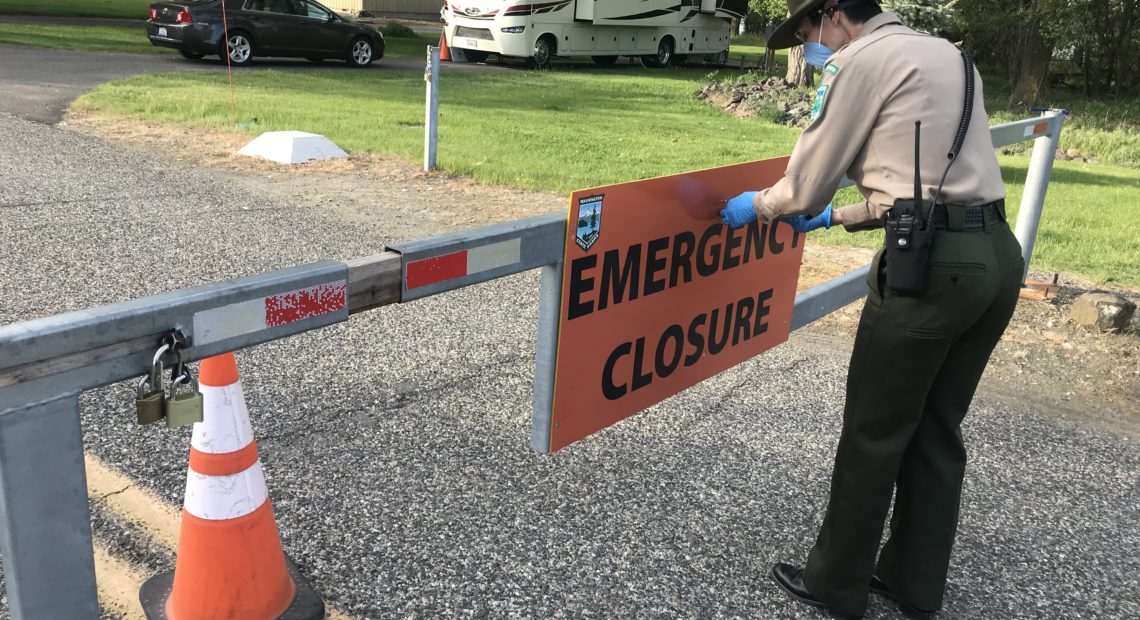 Washington State Parks area manager Audra Sims removes the “Emergency Closure” sign from the gate at Sacajawea Historical State Park, outside Pasco. The park re-opened to the public on May 5, after a nearly six-week closure. CREDIT: Courtney Flatt/NWPB