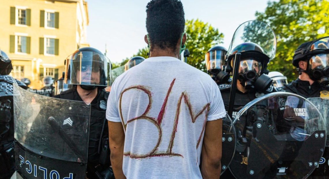 A protester stands in front of U.S. Secret Service officers at Lafayette Square near the White House on June 1 after the park was cleared for President Donald Trump's walk to the historic St. John's Church, which sustained minor fire damage during earlier demonstrations.