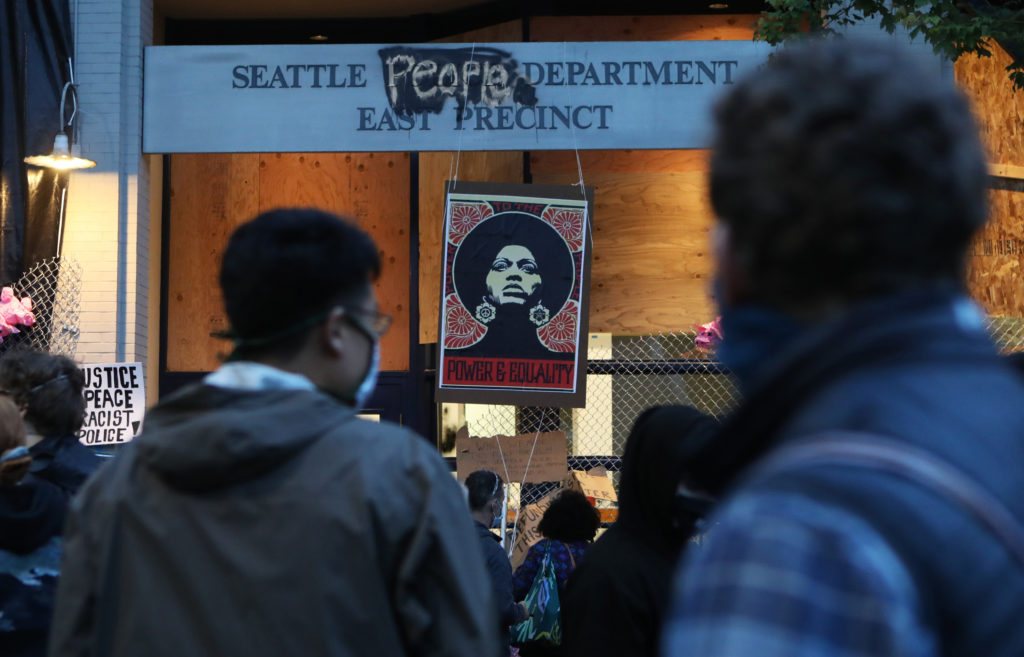 People gather near the vacated Seattle Police Department's East Precinct in the Capitol Hill Organized Protest zone of Seattle. The open-air protest camp is more than a week old. Makeshift clinics now stand on the streets where young protesters were injured by flash-bang grenades. CREDIT: Jim Urquhart for NPRv