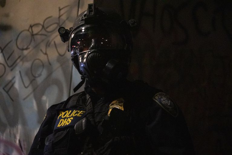 A Department of Homeland Security officer patrols the Mark O. Hatfield federal courthouse in Portland, Ore., July 25, 2020. CREDIT: Bradley W. Parks/OPB