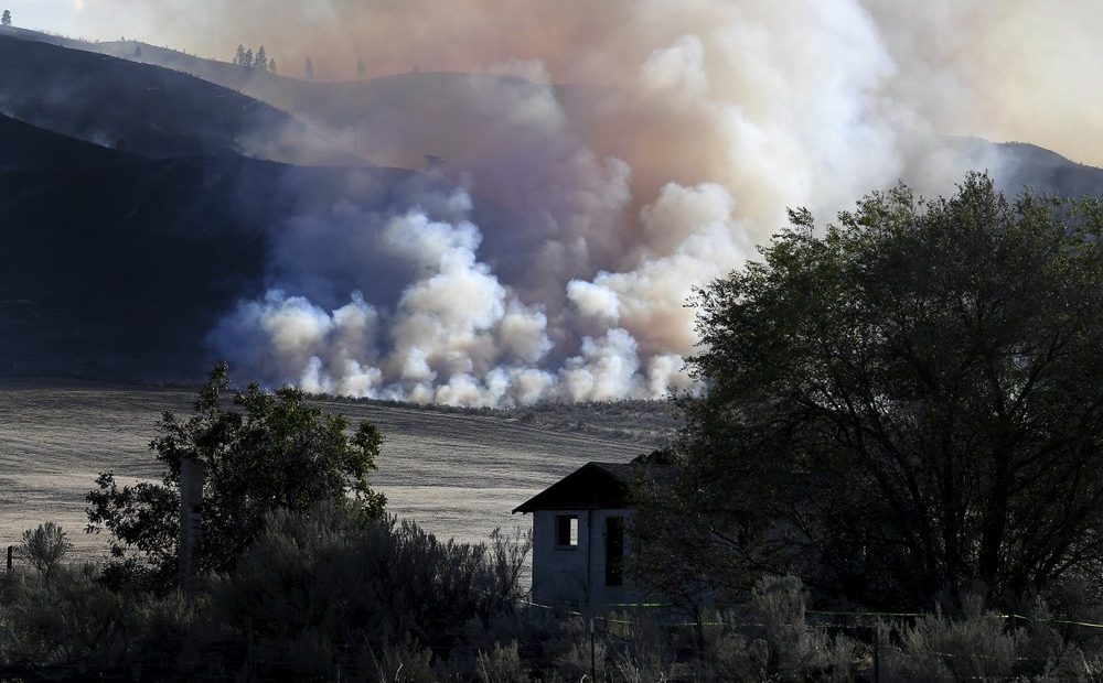 Late afternoon light catches smoke from the Cold Springs Fire near a structure that appeared to be empty long before the fire, Monday, Sept. 7, 2020, near Omak, Washington. CREDIT: Tyler Tjomsland/The Spokesman-Review via AP