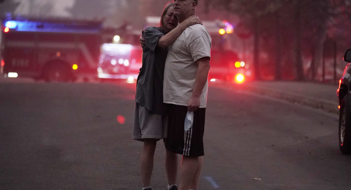 A couple embrace Thursday, Sept. 10, 2020, while touring an area devastated by the Almeda Fire in Phoenix, Ore. John Locher/AP