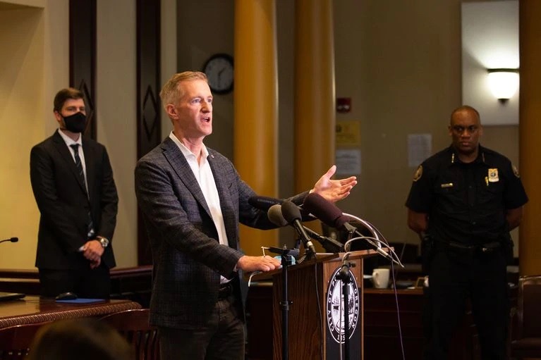 Mayor Ted Wheeler stands between Police Chief Chuck Lovell, right, and Multnomah County District Attorney Mike Schmidt at an Aug. 30 press conference. CREDIT: Bradley W. Parks / OPB