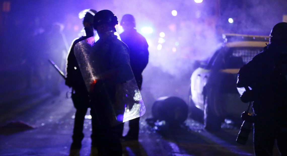 Police officers in Ferguson, Mo., during a protest in 2014. Advocates want the Justice Department to step up its oversight of law enforcement in the incoming administration. Charlie Riedel/AP