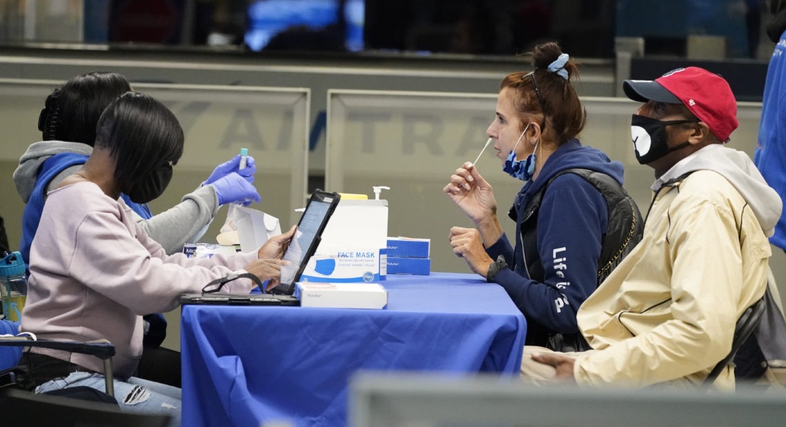 Travelers self-test for the coronavirus at a mobile testing site at New York City's Penn Station in the days leading up to Thanksgiving. The U.S. is currently seeing record hospitalizations for COVID-19, and health experts fear more surges are on their way. CREDIT: Mary Altaffer/AP