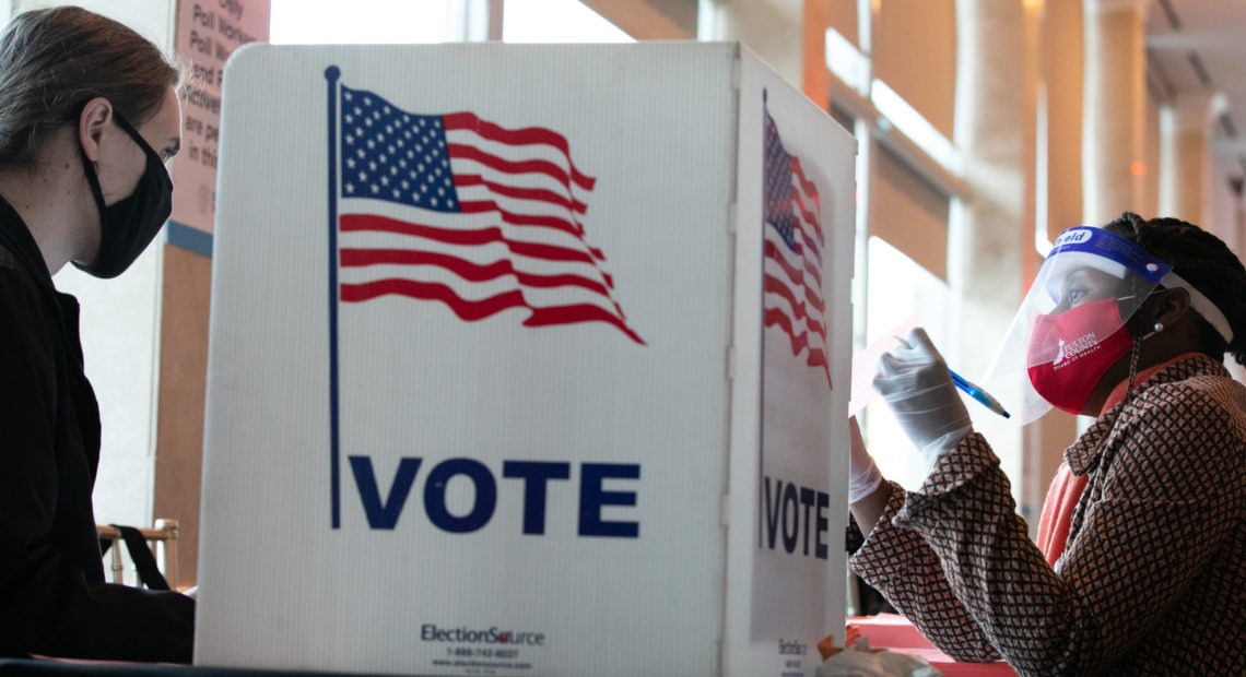 A poll worker helps K. Maki (left) fill out a provisional ballot at Park Tavern polling station on Tuesday in Atlanta, Ga. After a record-breaking early voting turnout, Americans head to the polls on the last day to cast their vote. CREDIT: Jessica McGowan/Getty Images