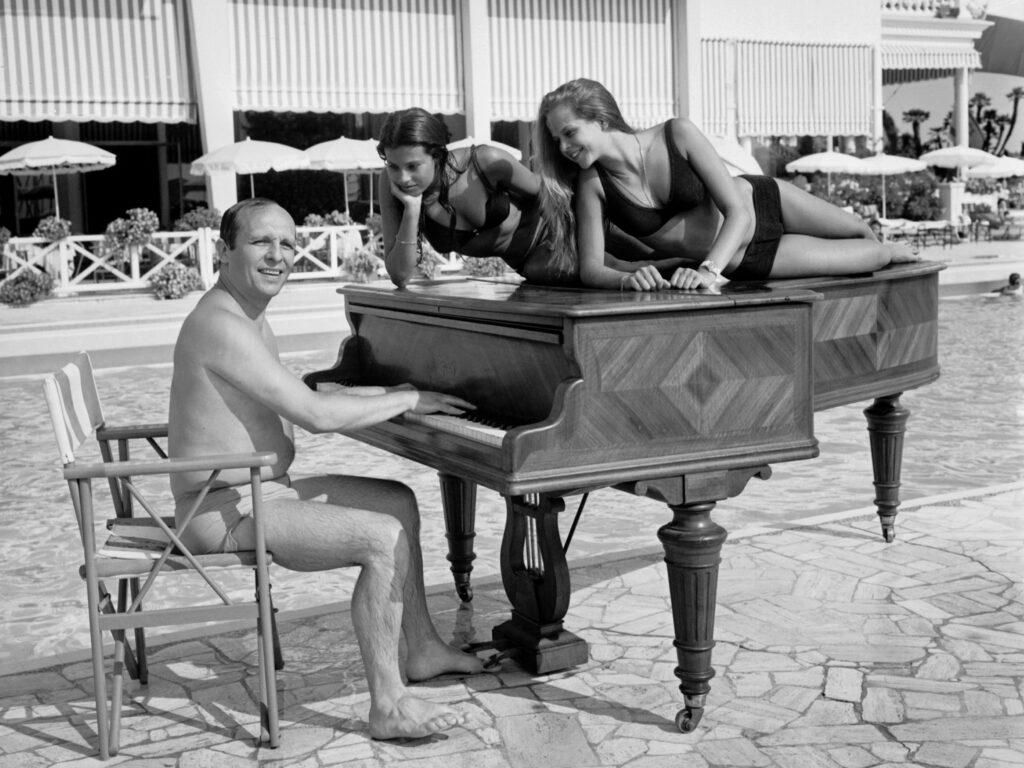 A shot of jazz pianist Claude Bolling and friends, taken on a beach in Cannes, France in 1969. CREDIT: AFP via Getty Images