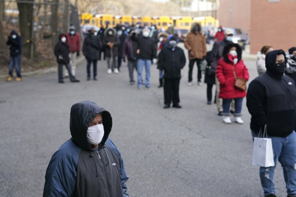 People wait in line for the COVID-19 vaccine in Paterson, N.J., Thursday, Jan. 21, 2021. Some hospitals around the U.S. are facing complaints about favoritism and line-jumping after their board members and donors received COVID-19 vaccinations or offers for inoculations. CREDIT: Seth Wenig/AP