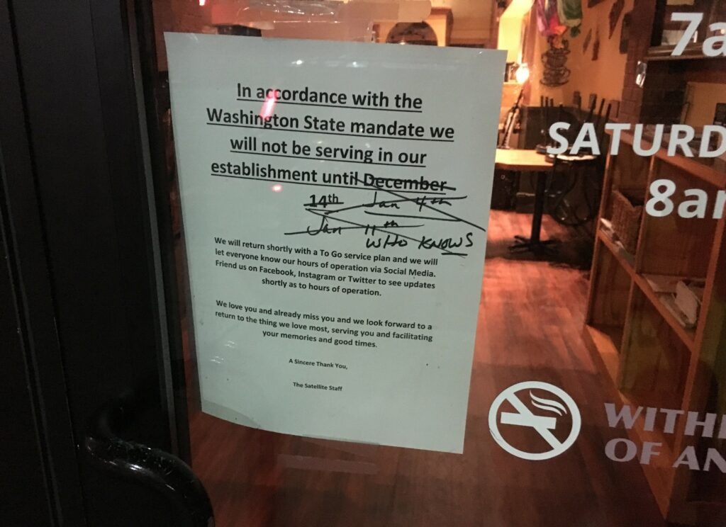 Sign on restaurant door in Spokane saying when it will reopen from covid closure with multiple dates crossed out and finally saying 