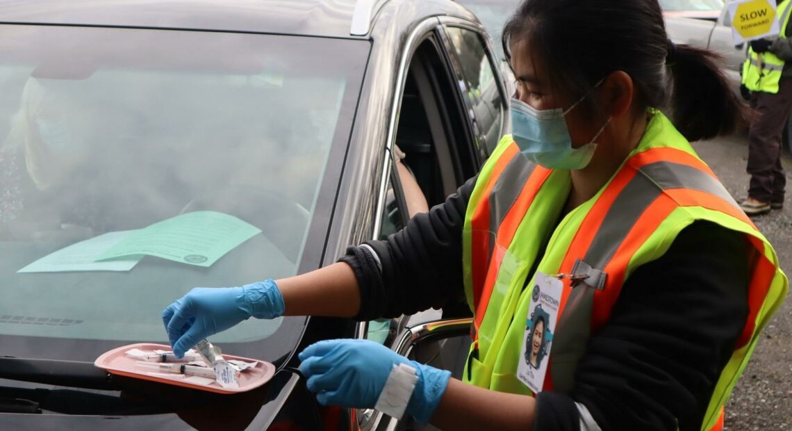 After an hours-long wait, drivers pull up under a vaccination tent to get their first dose of the Moderna COVID vaccine on Thursday, Jan. 14, 2021. CREDIT: Tom Banse/N3