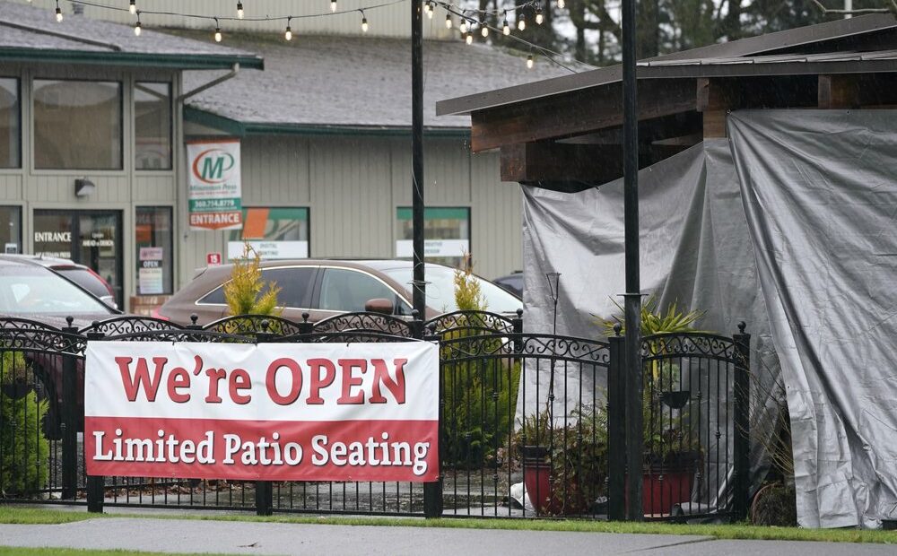 A sign at the El Sarape restaurant advertises outdoor seating, Jan. 5, 2021, in Olympia, Wash., as indoor dining was prohibited statewide due the the governor's coronavirus safety measures. CREDIT: Ted S. Warren/AP