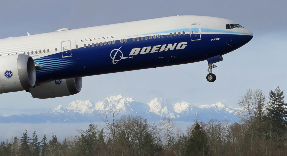 Boeing 777-X jet takes off in Seattle with Olympia Mountains in the background