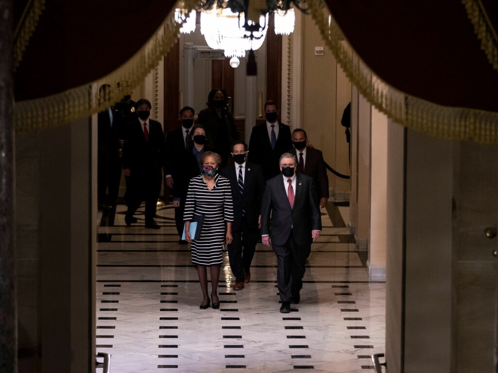 L-R: U.S. House Clerk Cheryl Johnson, Rep. Jamie Raskin and Rep. David Cicilline walk walk through the Capitol's Statuary Hall to deliver the article of impeachment for incitement of insurrection against former President Trump to the Senate floor on Monday evening. Tasos Katopodis/Pool/AFP via Getty Images