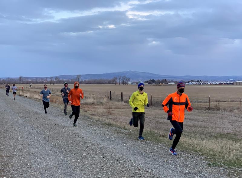 Ellensburg High School coach Jeff Hashimoto, in orange, leads masked cross-country team members on a long training run on February 8. CREDIT: Tom Banse/N3