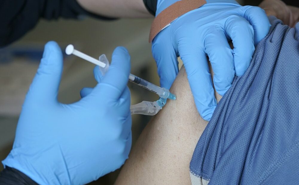 Kristin May, an EMT with the Seattle Fire Dept., gives the first dose of the Moderna COVID-19 vaccine to a patient at a City of Seattle community COVID-19 testing and vaccination clinic in Seattle's Rainier Beach neighborhood in February 2021. CREDIT: Ted S. Warren/AP